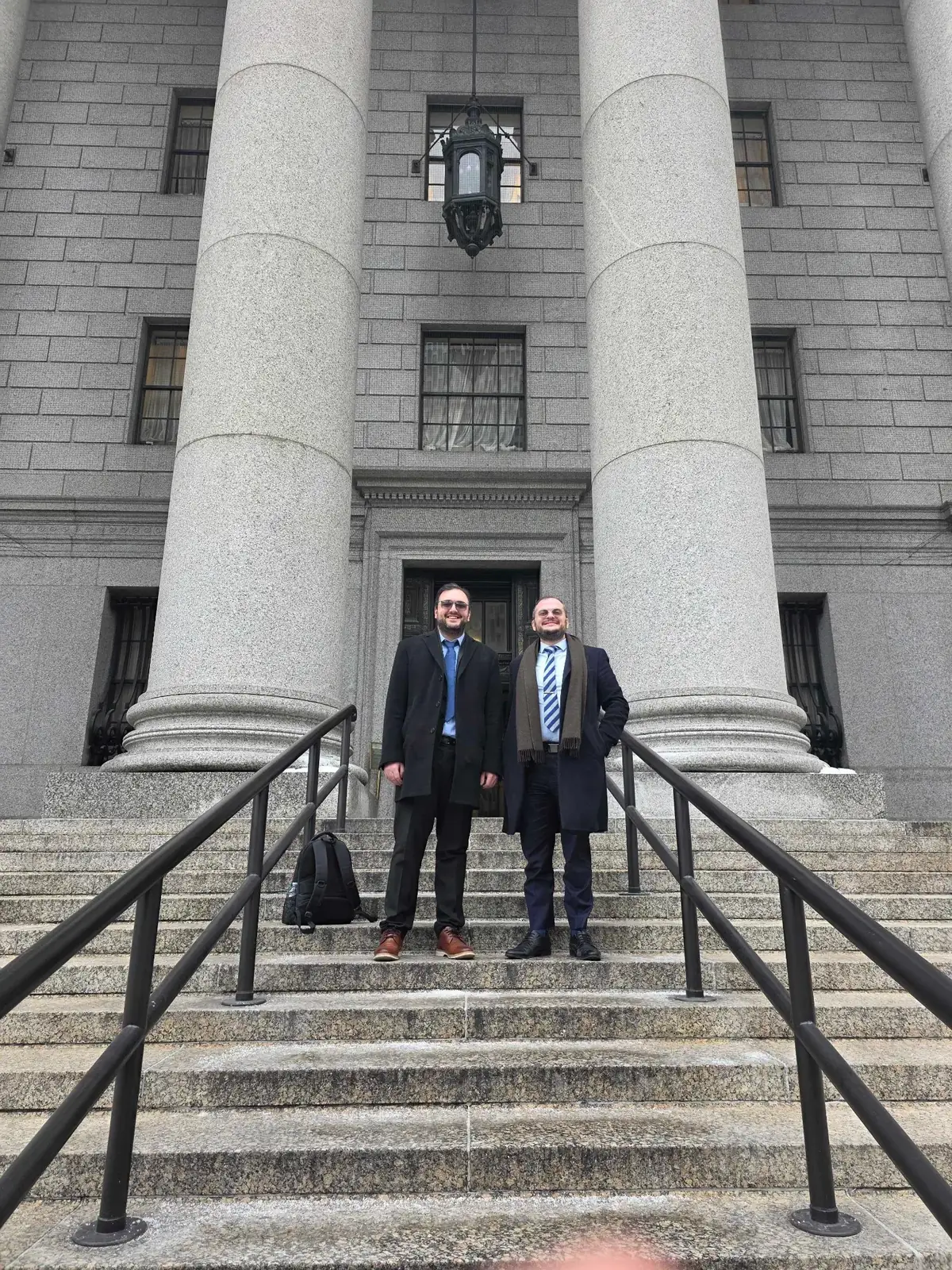 Federal courthouse columns with Usher Law Group attorneys on the courthouse steps